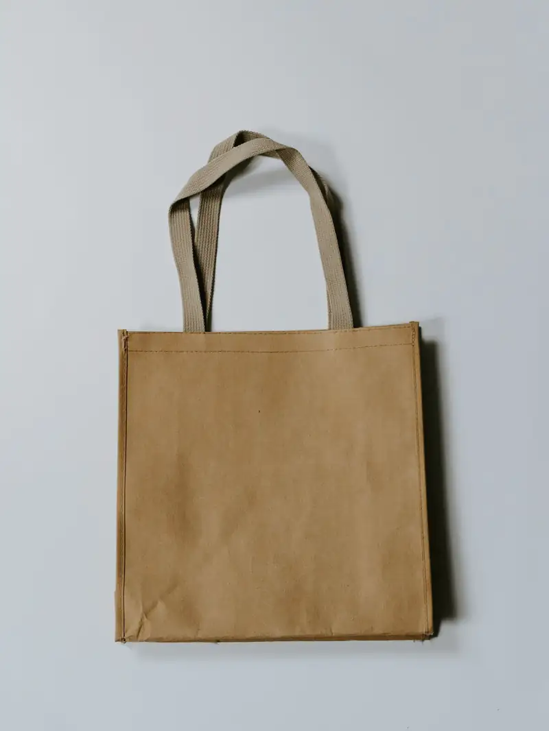 Bolsa de tela cruda con asas de cinta sobre un fondo gris azulado