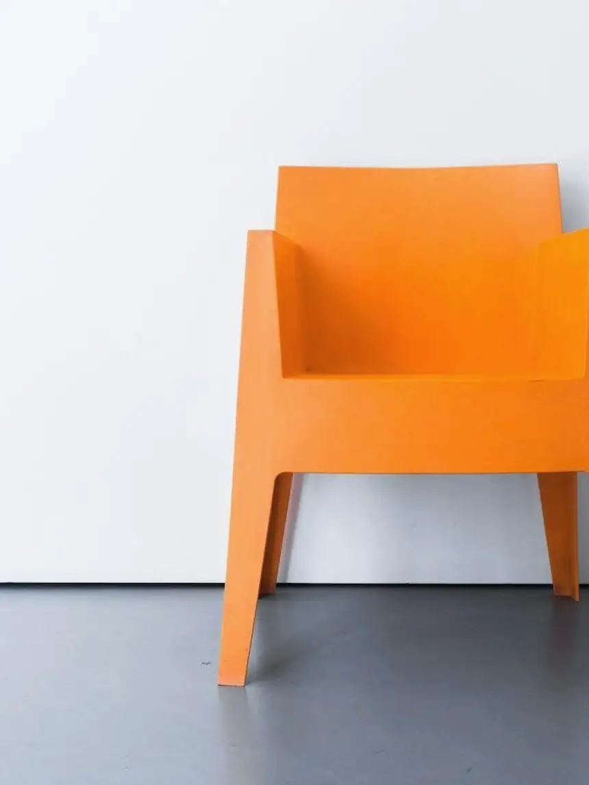 Sillón naranja contra una pared blanca