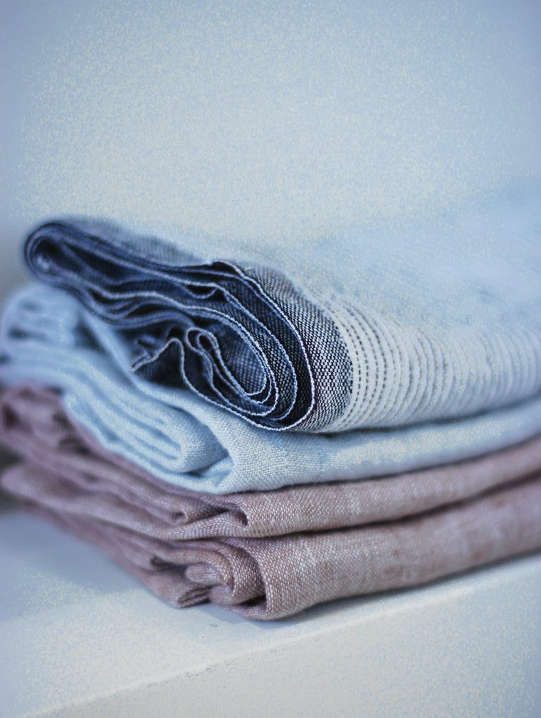 Servilletas de lino dobladas, en azul grisáceo y malva