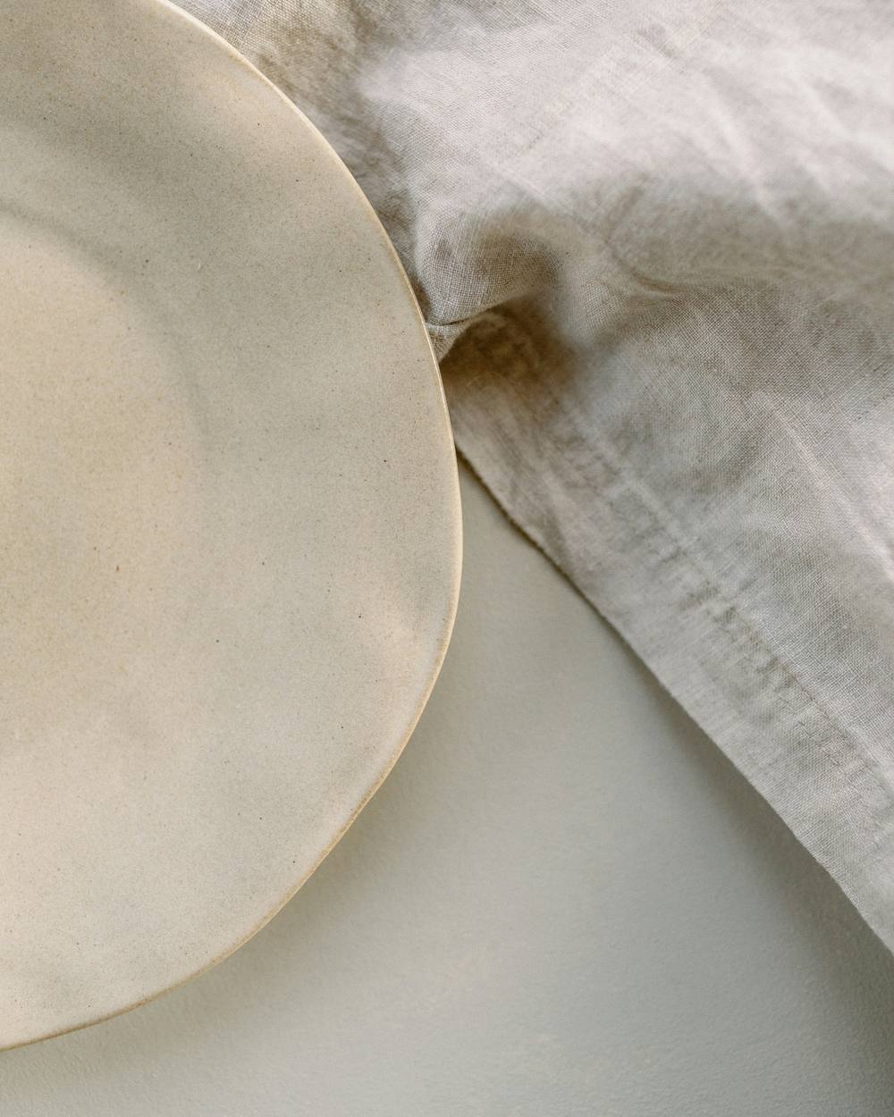 Borde de un plato crudo sobre un mantel de lino