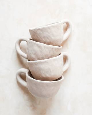 Tazas de barro claro apiladas, con sus asas