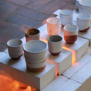 Vasos de gres sobre ladrillos refractarios, con un resplandor anaranjado