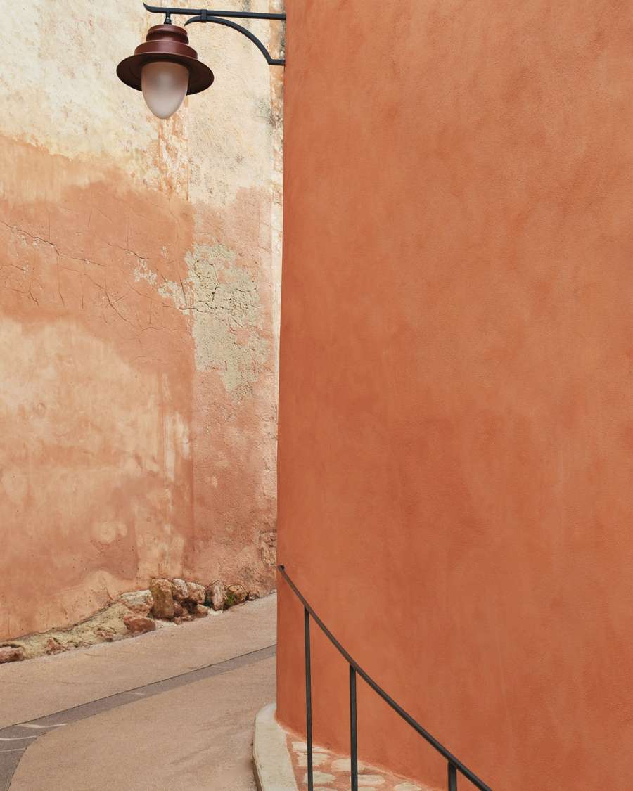 Un callejón de muros ocre con un farol de hierro