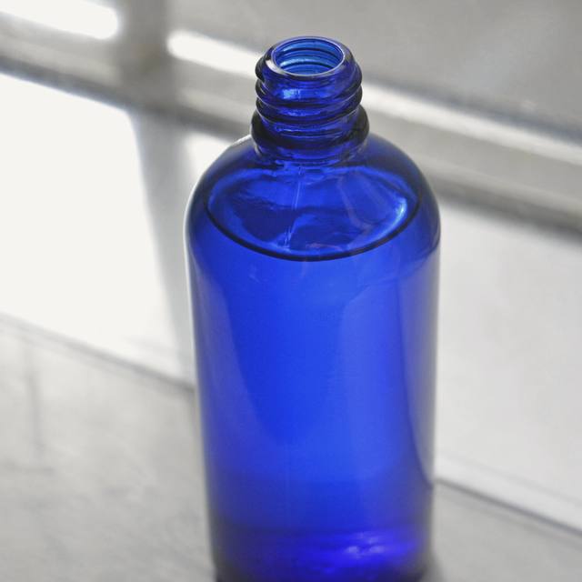 Un frasco de vidrio azul cobalto con luz de ventana