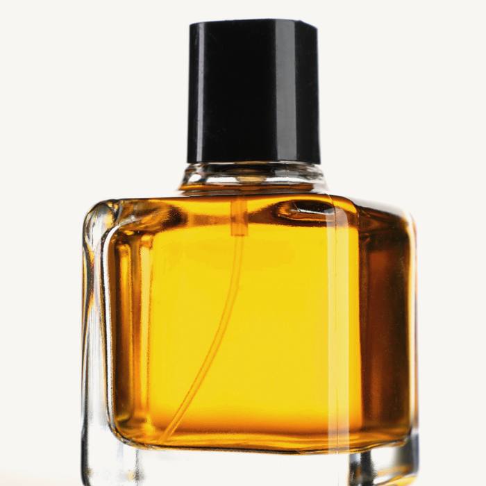 Un frasco de vidrio con tapa negra y perfume ámbar