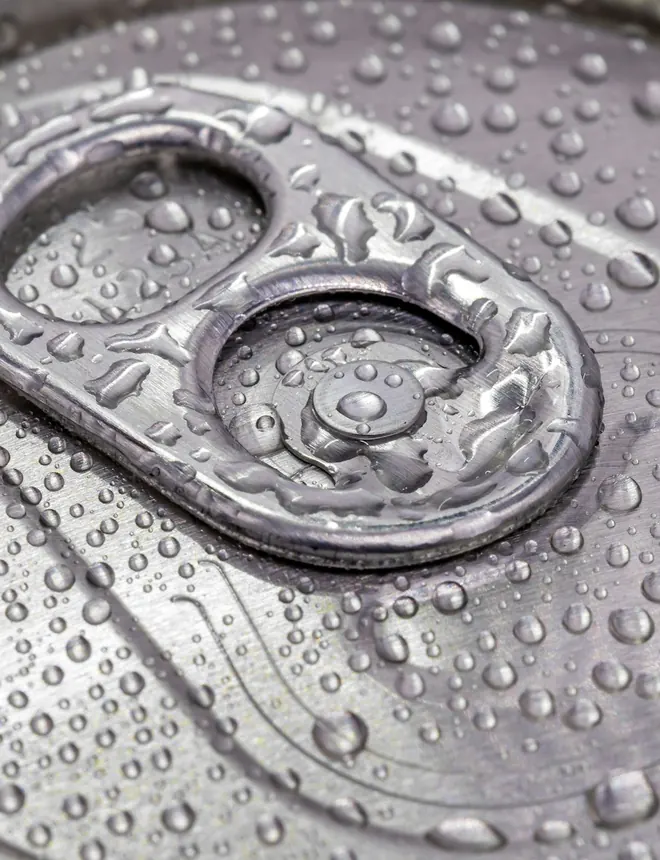 Primer plano de la tapa de una lata de aluminio cubierta de gotas de agua