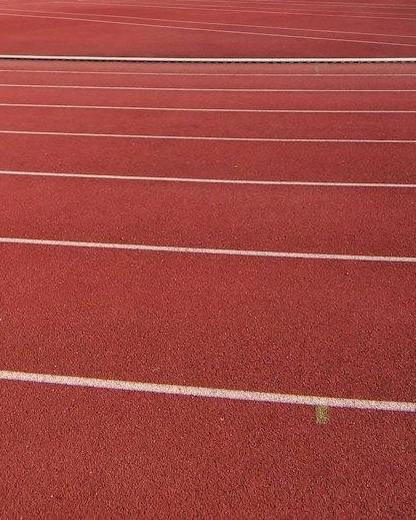 Pista de atletismo roja con líneas blancas