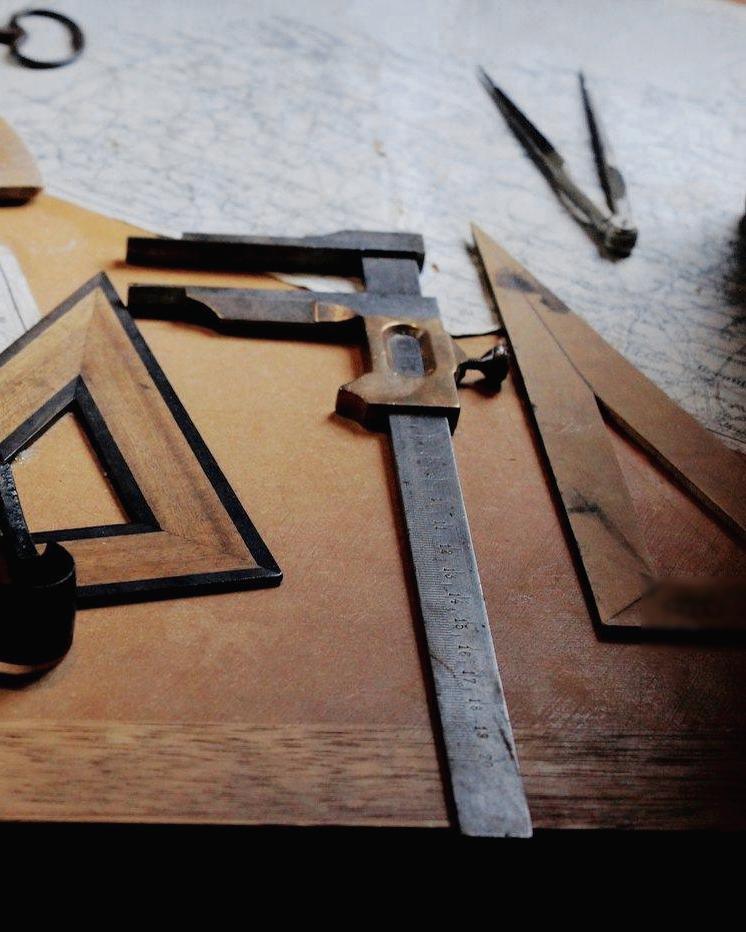 Escuadras, compás y regla sobre una mesa de dibujo