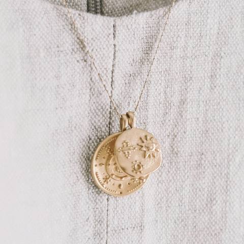 Colgante de moneda dorado sobre una tela de lino