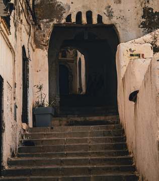 Escalinata bajo un arco de muros claros