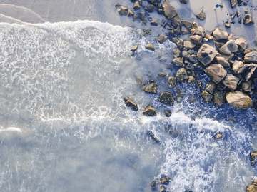 Olas sobre bloques de piedra en la orilla