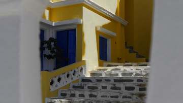 Fachada amarilla con postigos azules