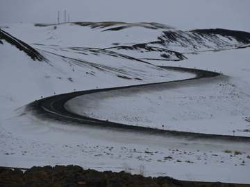 Curva de carretera sobre colinas nevadas