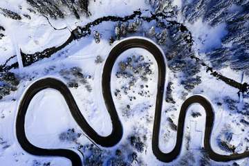 Curvas de una carretera en el bosque nevado, desde el aire