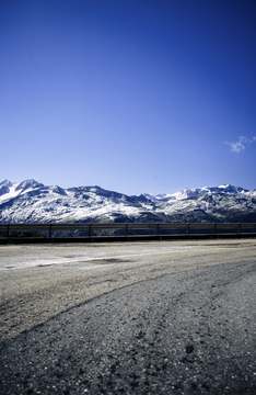 Cumbres nevadas sobre un camino de ripio