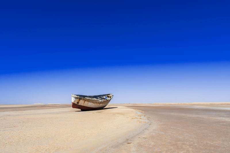Un bote solitario sobre una llanura de sal bajo el cielo azul