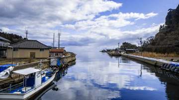Bote blanco y reflejos de nubes en un canal