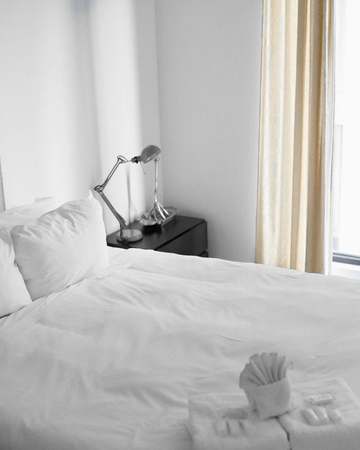 Cama blanca junto a una ventana