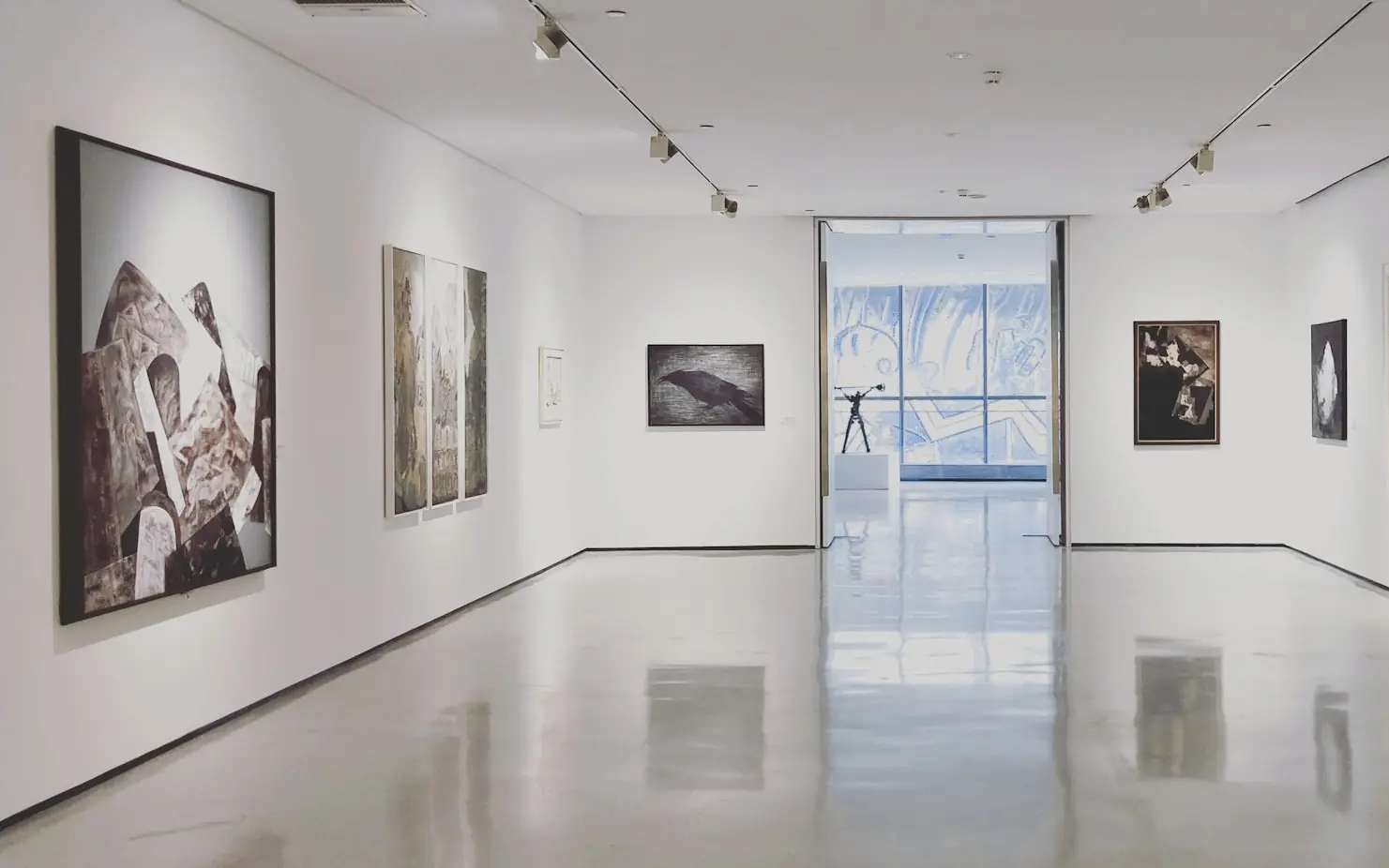 Sala de una galería de arte con cuadros en las paredes blancas