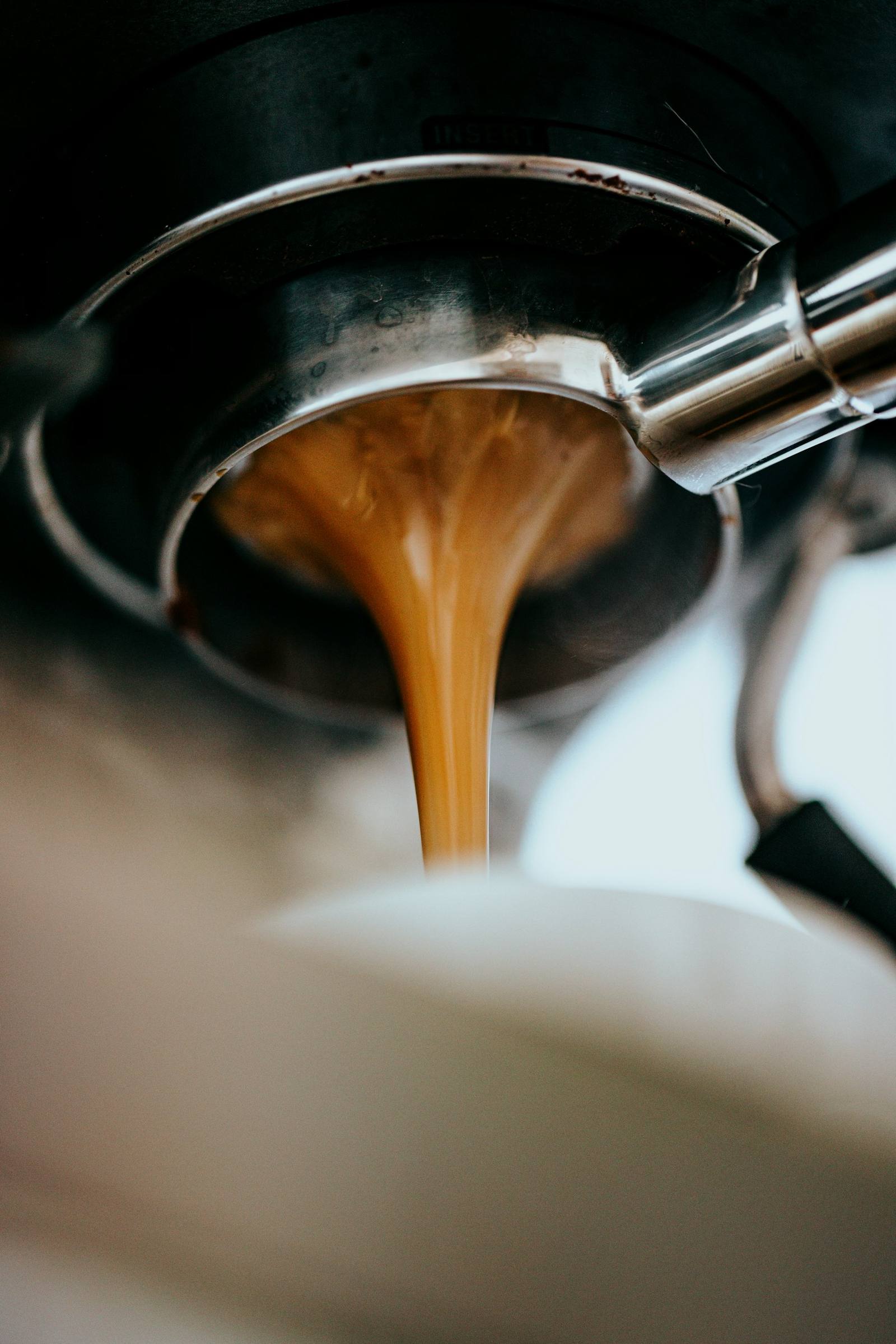 Espresso cayendo desde un portafiltro sin fondo