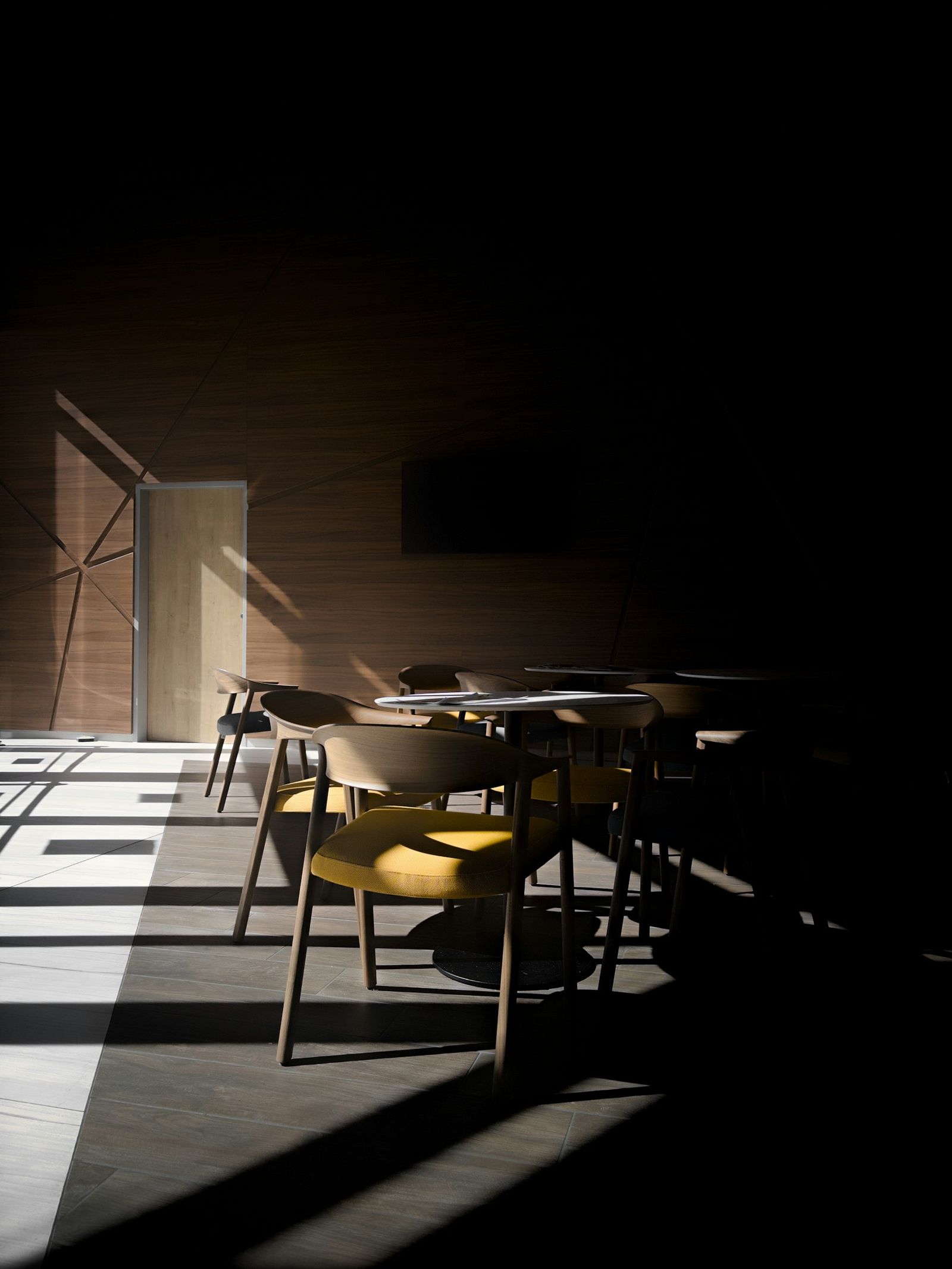 Sala del café en penumbra con luz de ventana sobre las sillas