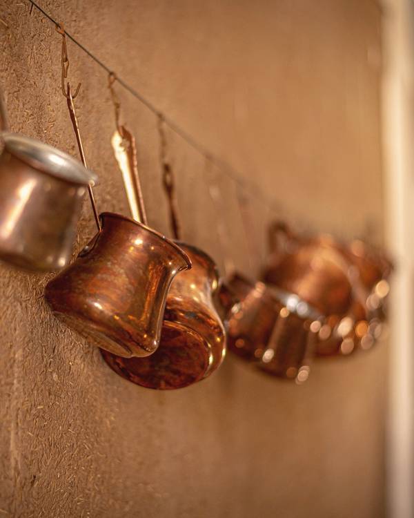 Tazas de cobre colgadas en una pared