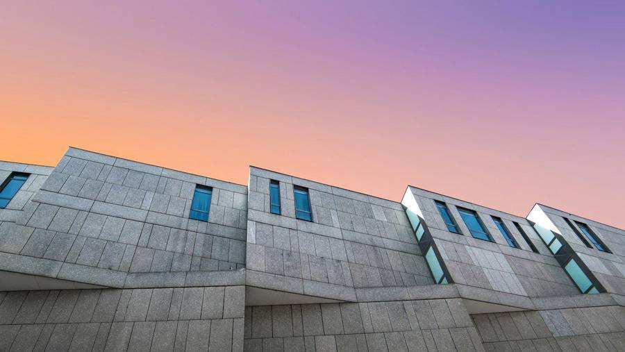 Fachada de hormigón en contrapicado, con el cielo del atardecer