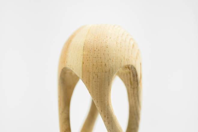 Escultura de madera clara con patas curvas