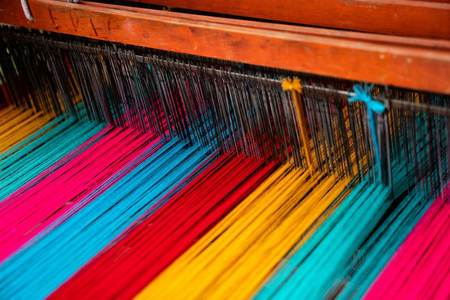 Hilos de colores tensados en un telar