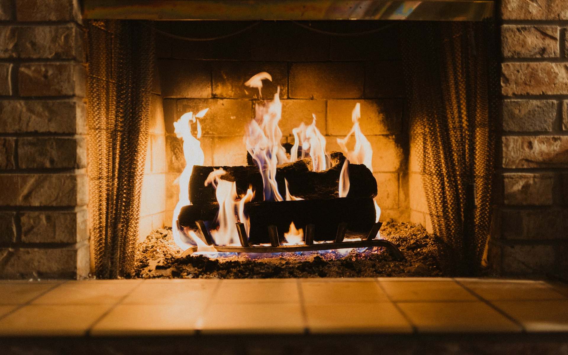 Leños ardiendo en una chimenea de ladrillo