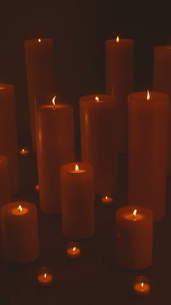 Velas altas encendidas en la penumbra