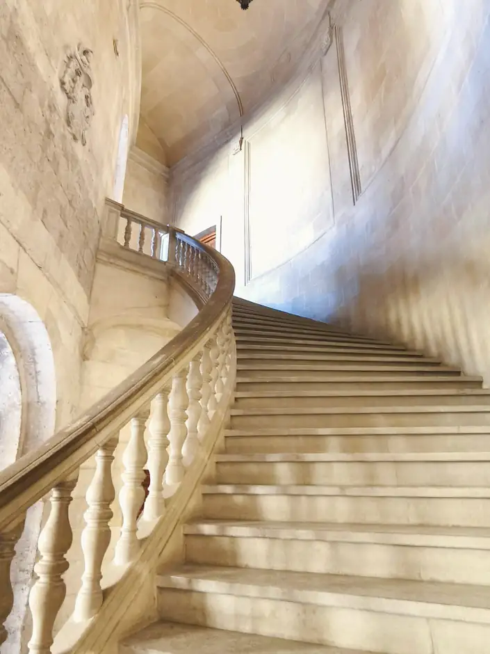 Escalera de piedra con balaustrada curva y luz suave
