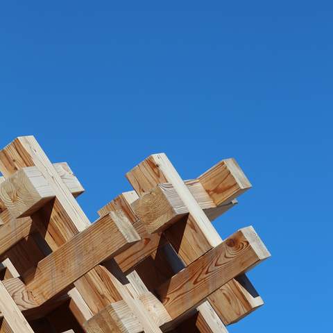 Cruce de piezas de madera bajo un cielo azul