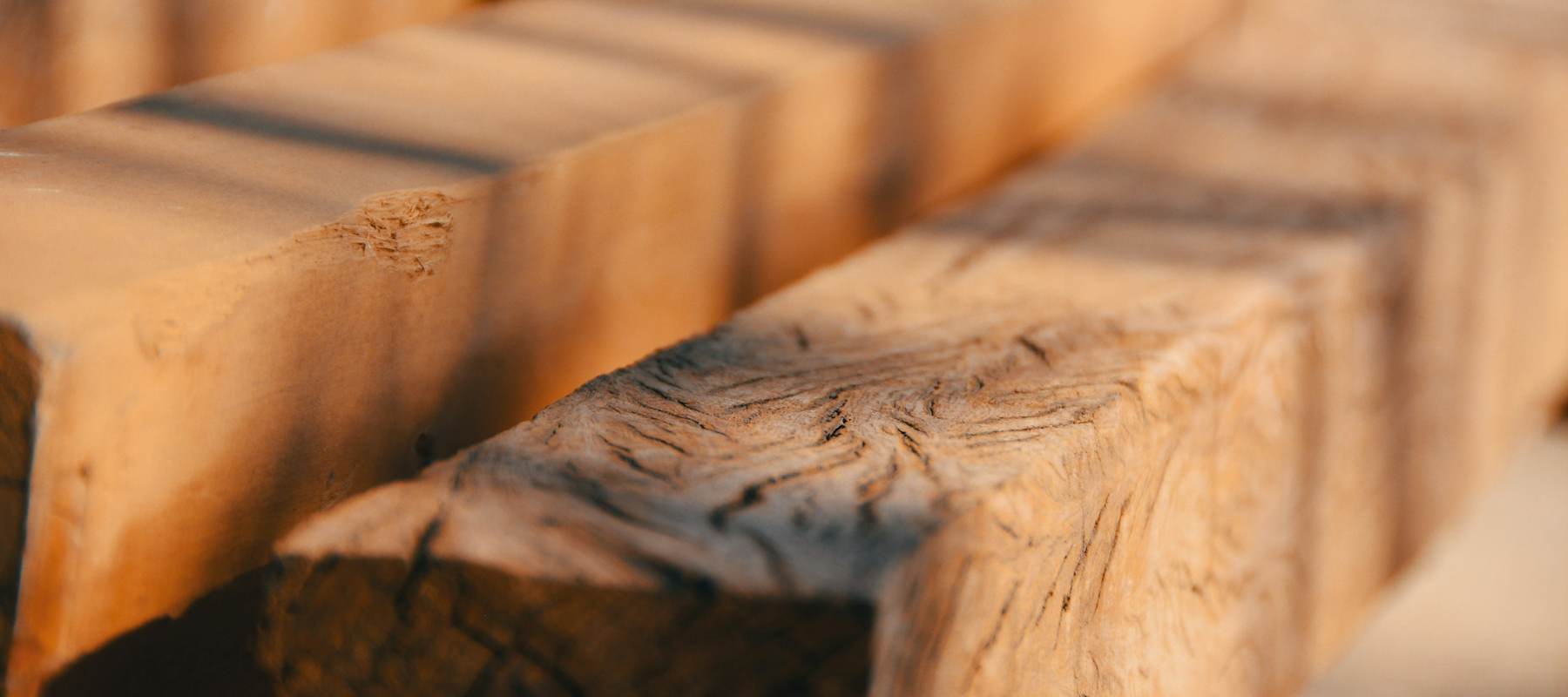 Vigas de madera de pino vistas de cerca, con la veta y la luz sobre la escuadría