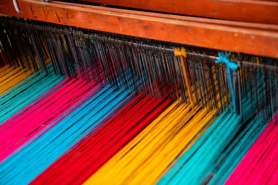 Hilos de colores intensos tensados en un telar, referencia para una paleta