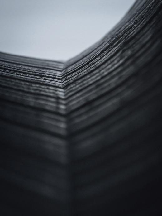 Esquina de una pila de papel oscuro