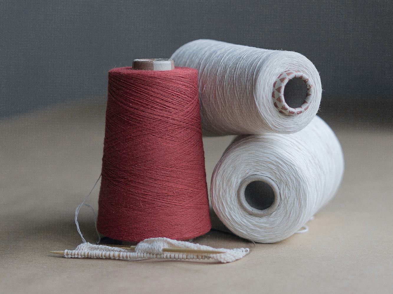 Conos de hilo rojo y blanco sobre una mesa