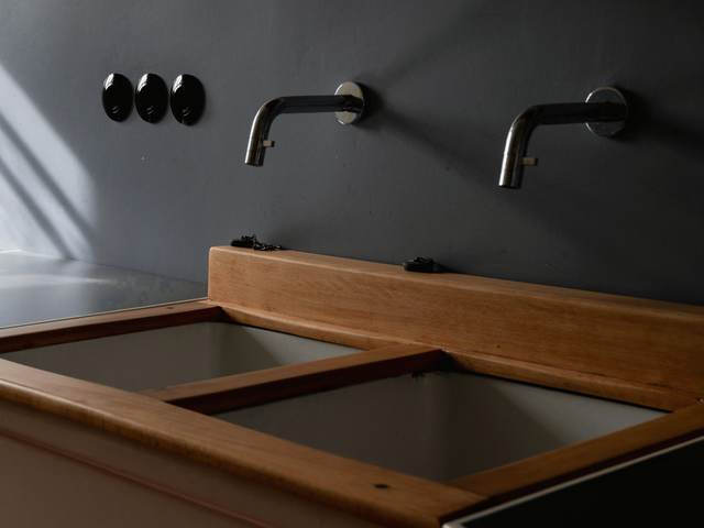 Dos grifos de pared sobre una artesa de madera