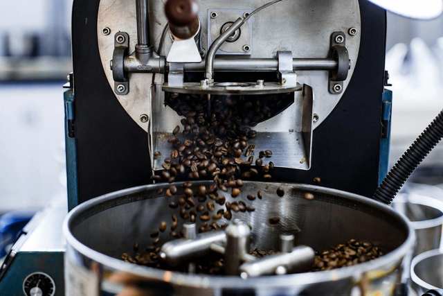 Granos de café cayendo de una tostadora