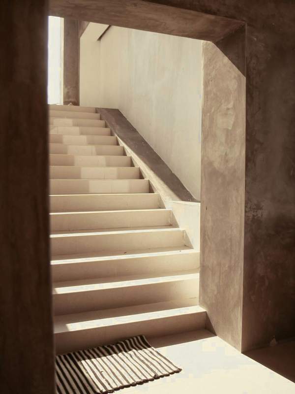 Escalera iluminada entre muros de piedra