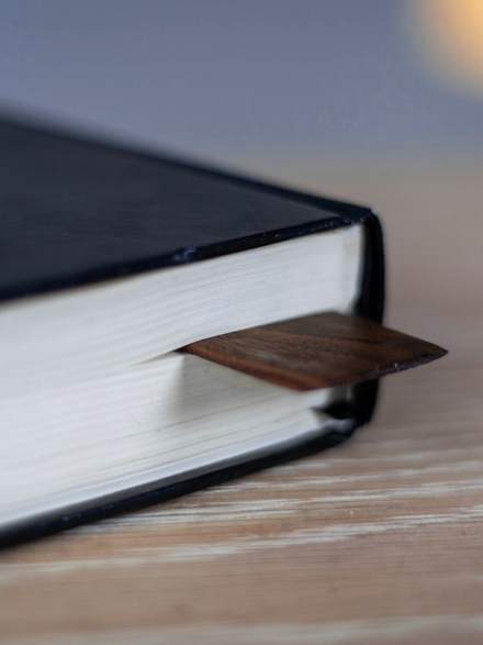 Esquina de un libro negro con un marcador de cuero