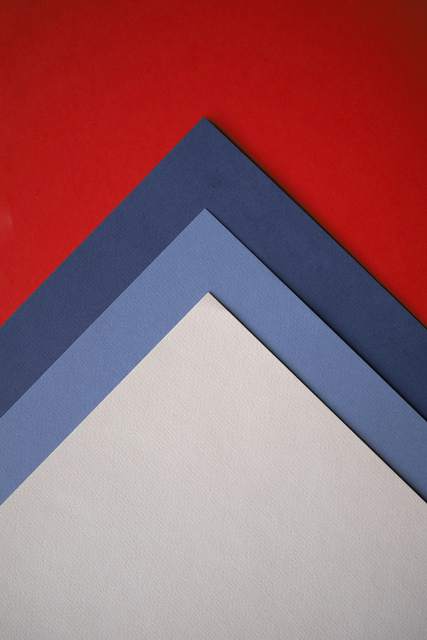 Cartulinas roja, azul y gris dobladas en ángulo