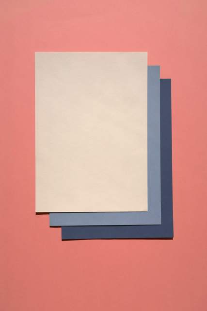 Pliegos de papel superpuestos sobre un fondo salmón