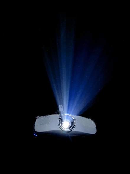 Proyector que lanza un haz de luz en la oscuridad