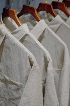 Camisas de lino colgadas de perchas de madera
