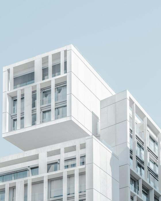Edificio blanco de volúmenes apilados contra un cielo claro