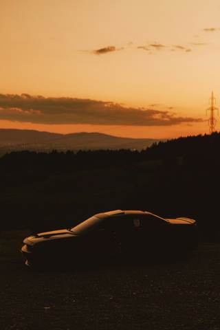 Silueta de un auto contra el cielo del atardecer