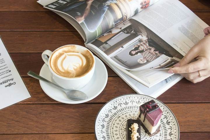 Revista y taza de café sobre una mesa de madera