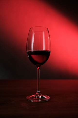 Copa de vino tinto sobre fondo rojo