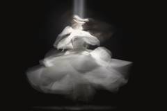Giro de una falda blanca captado en movimiento sobre fondo oscuro
